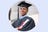 Smiling Male graduate in cap and gown holding diploma