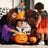 Happy family carving pumpkins in costumes