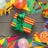 Colorful party supplies and construction paper with yellow abnd red gift with green ribbon and bow in center