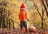 Smiling boy in leaves with pumpkin
