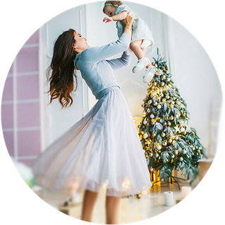 Woman with child in front of christmas tree